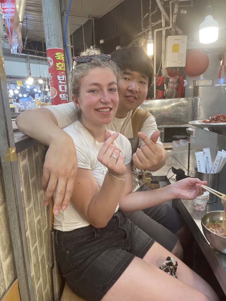 Charlie at a Korean food market eating noodles